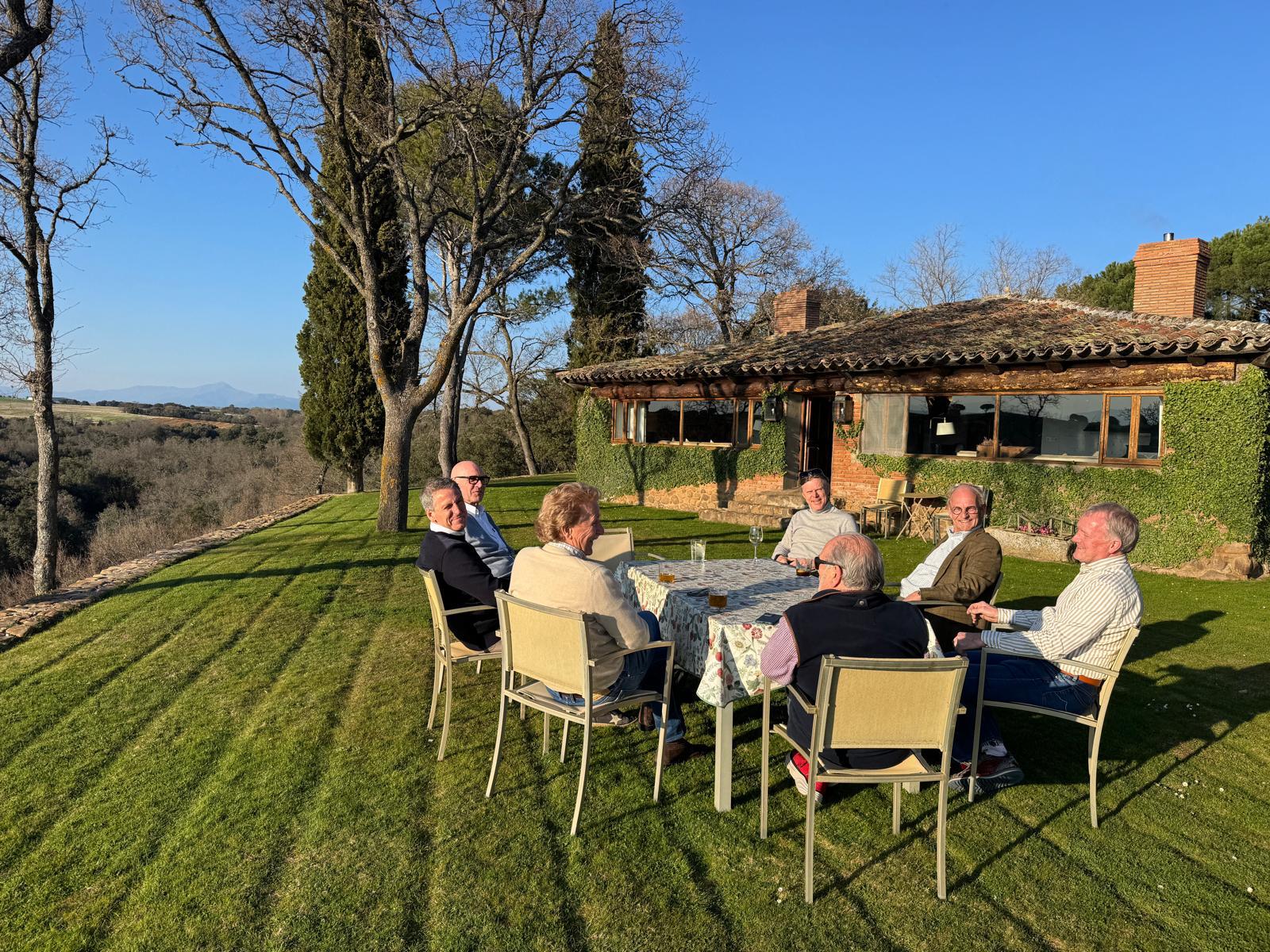 Guests at a table on the lawn outside the lodge at Fuentelfresno, open country beyond