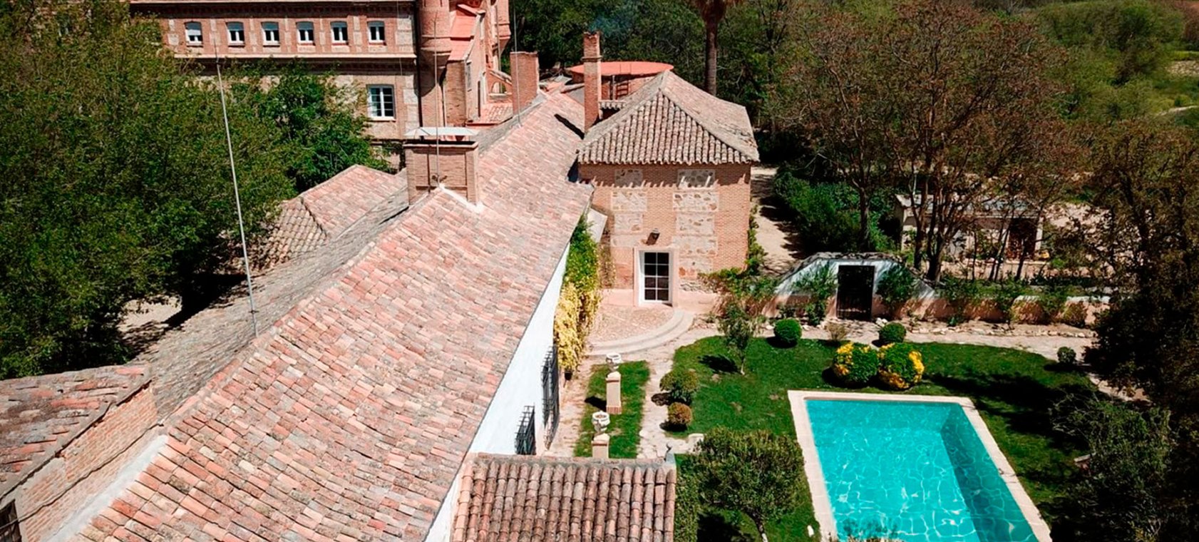 The old tiled roofs at Ventosilla seen from above, with a walled garden and swimming pool